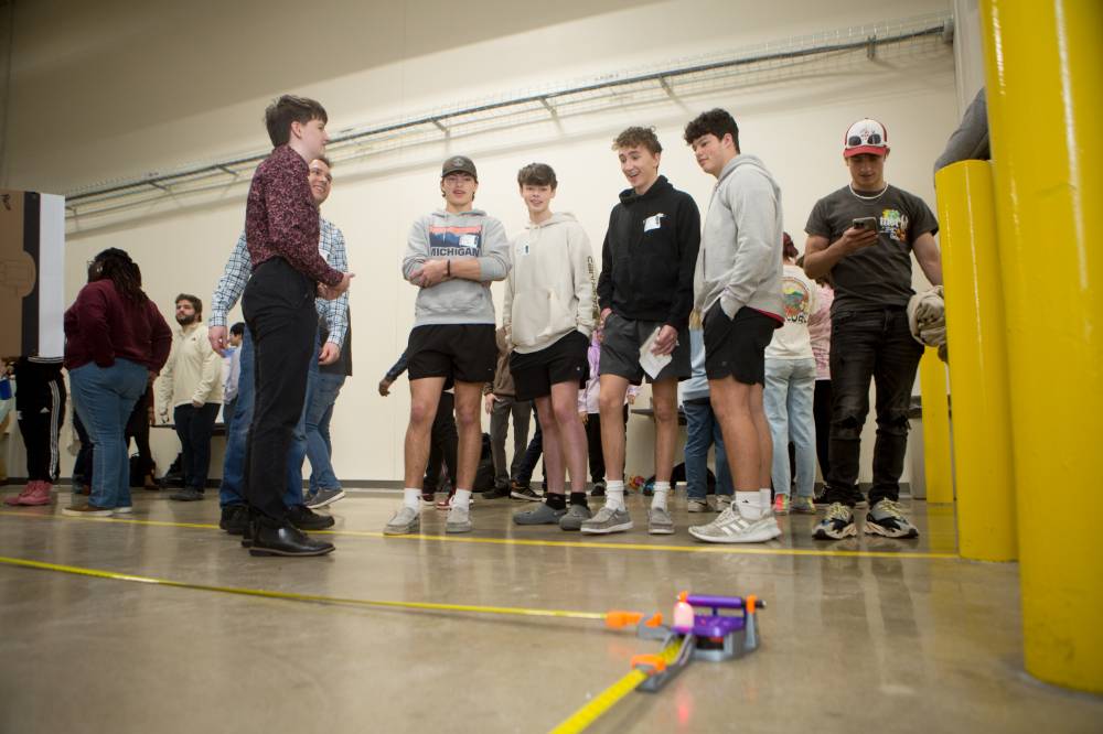 high school students interacting with a laser project
